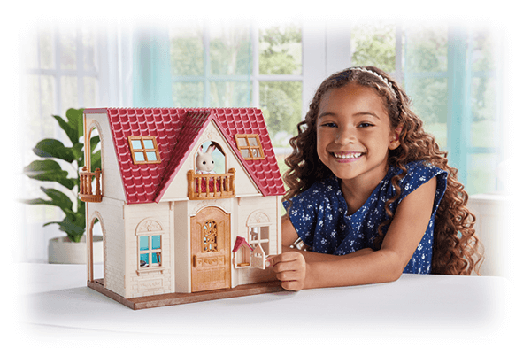 A girl playing with a Calico Critters house